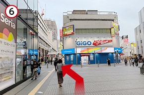 GIGOに突き当たったら斜め左に進みます。（左手の宝くじ売場・三菱UFJ銀行のビル内に事務所があります。）