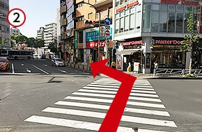 「Mister Donuts」方面へ横断歩道を渡り、「紳士服コナカ」側の道を直進します。